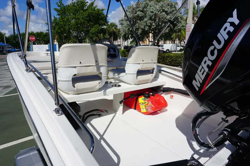 Slide: The Image of 2026 Boston Whaler 130 Super Sport boat interior with Mercury engine, white seats, and fuel tank. - 10