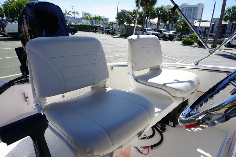 Slide: The Image of 2026 Boston Whaler 130 Super Sport boat interior with white seating and steering wheel. - 13