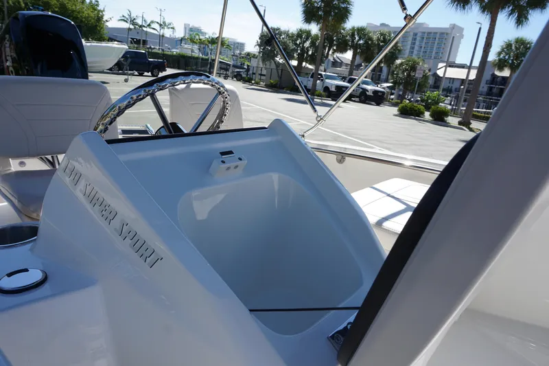 Slide: The Image of 2026 Boston Whaler 130 Super Sport boat interior with steering wheel and seating. - 16