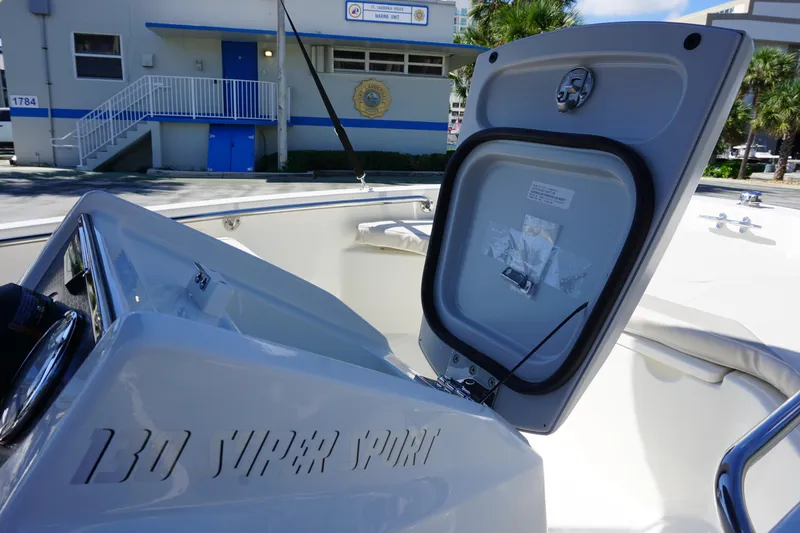 Slide: The Image of 2026 Boston Whaler 130 Super Sport boat interior with open storage compartment. - 17