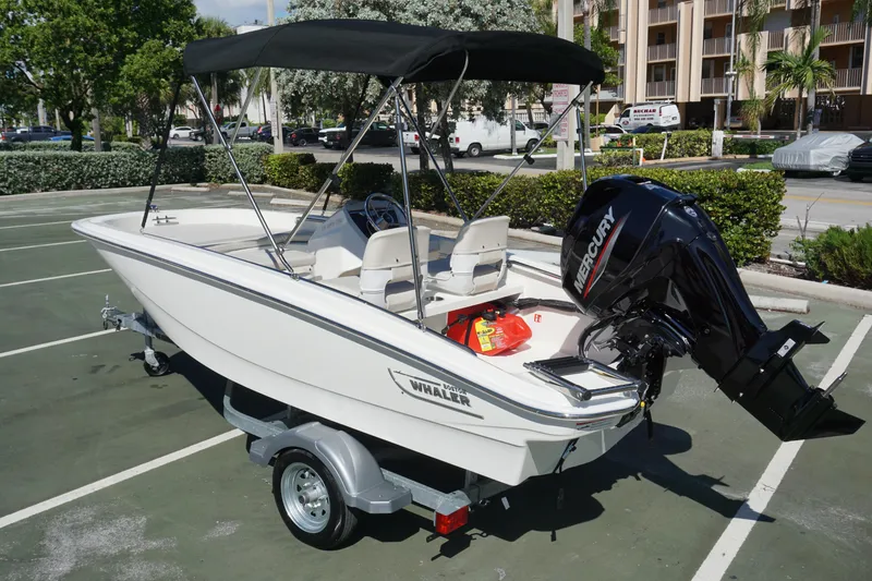 Slide: The Image of 2026 Boston Whaler 130 Super Sport boat with Mercury engine on trailer. - 2