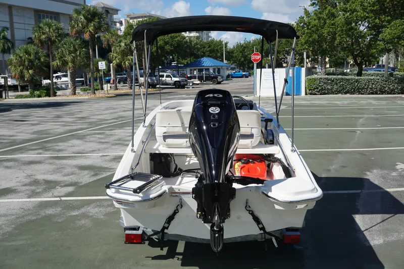 Slide: The Image of 2026 Boston Whaler 130 Super Sport boat with outboard motor in a parking lot. - 3