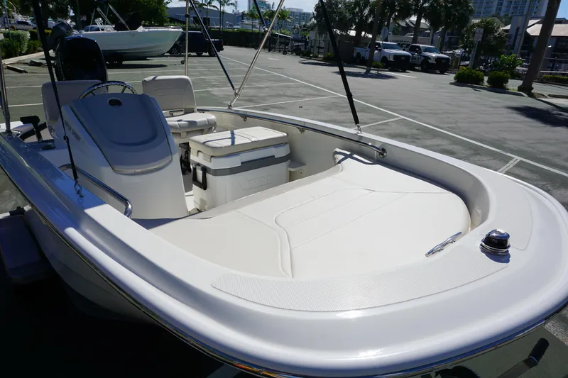 Slide: The Image of 2026 Boston Whaler 130 Super Sport boat, sleek design, parked outdoors in a sunny setting. - 7