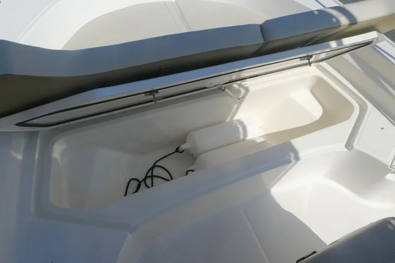 Slide: The Image of 2022 Boston Whaler 190 Montauk storage compartment with open lid, showcasing interior space. - 10