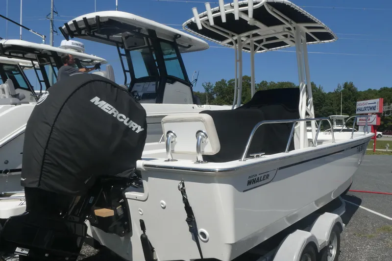 Slide: The Image of 2022 Boston Whaler 190 Montauk boat with Mercury engine, displayed outdoors. - 2