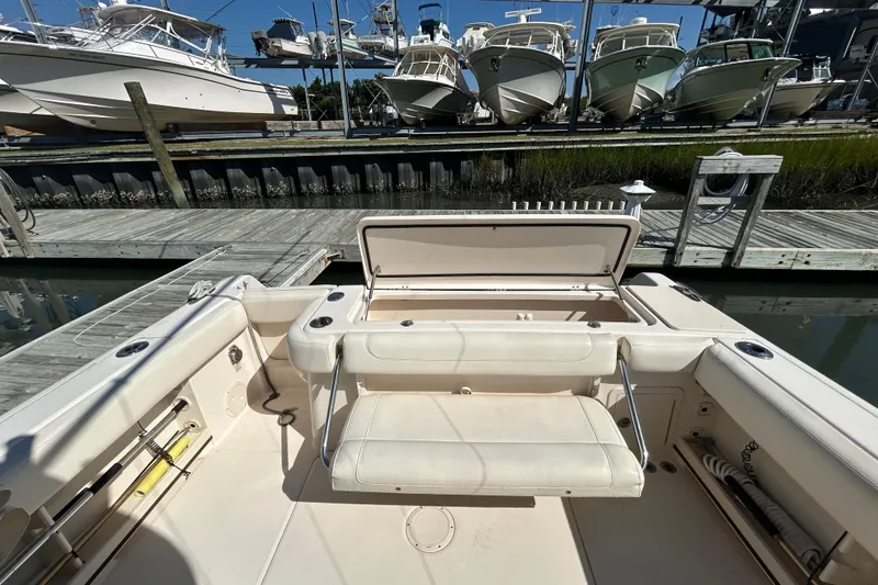 Slide: The Image of 2020 Grady-White Canyon 306 boat interior with open storage, docked near other boats. - 12