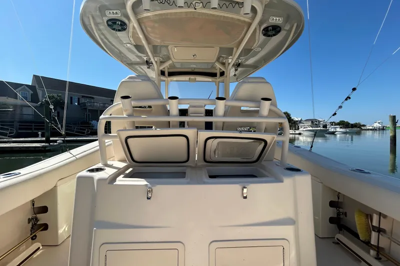 Slide: The Image of 2020 Grady-White Canyon 306 boat interior with rod holders and storage, docked in a marina. - 19