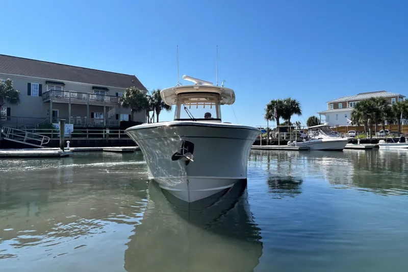 Slide: The Image of 2020 Grady-White Canyon 306 boat docked in a sunny marina setting. - 2