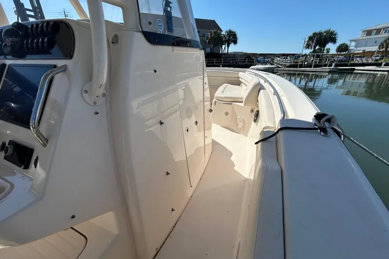 Slide: The Image of 2020 Grady-White Canyon 306 boat interior, docked in a marina under clear blue skies. - 29