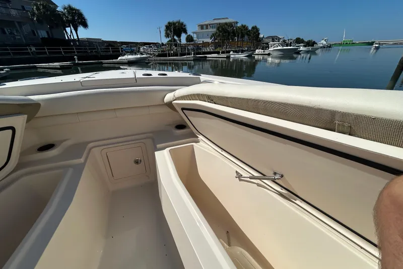 Slide: The Image of 2020 Grady-White Canyon 306 boat interior with open storage, docked in a marina. - 36