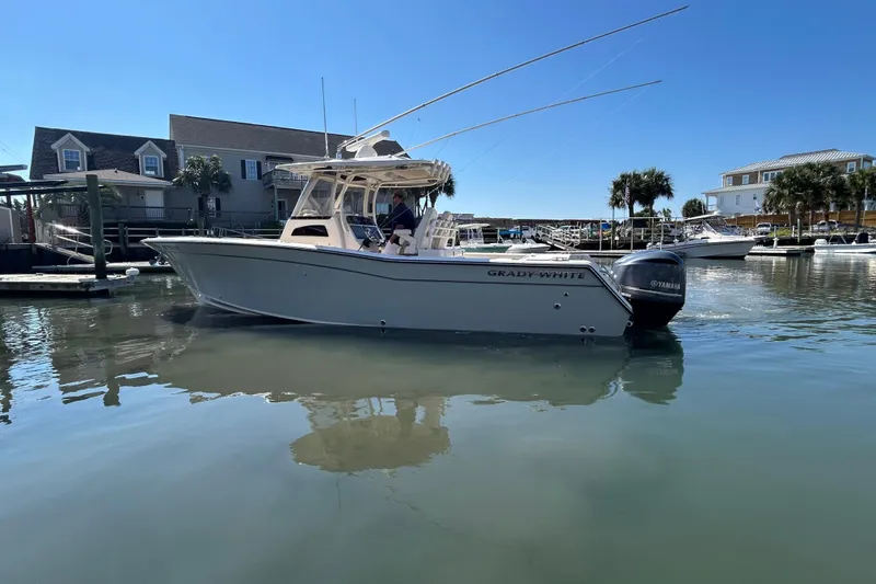 Slide: The Image of 2020 Grady-White Canyon 306 boat docked in a marina under clear blue skies. - 6