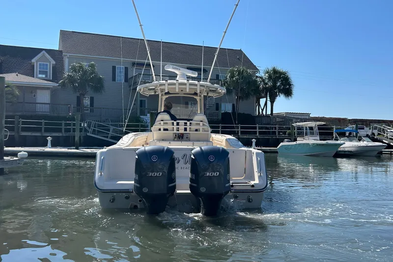 Slide: The Image of 2020 Grady-White Canyon 306 boat with dual engines docked near waterfront homes. - 8
