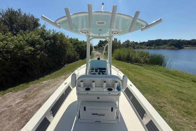 Slide: The Image of 2026 Pathfinder 2200 TRS boat on grassy shore near a lake, sunny day. - 13