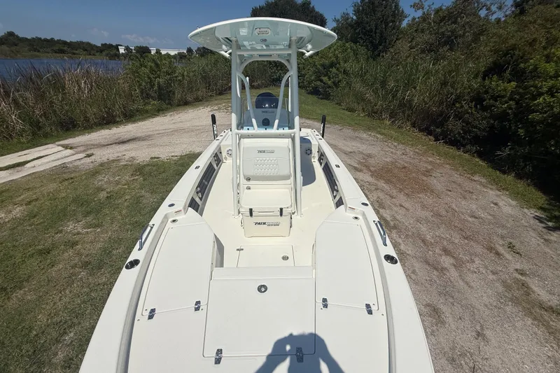 Slide: The Image of 2026 Pathfinder 2200 TRS boat on grassy shore near water and trees. - 19