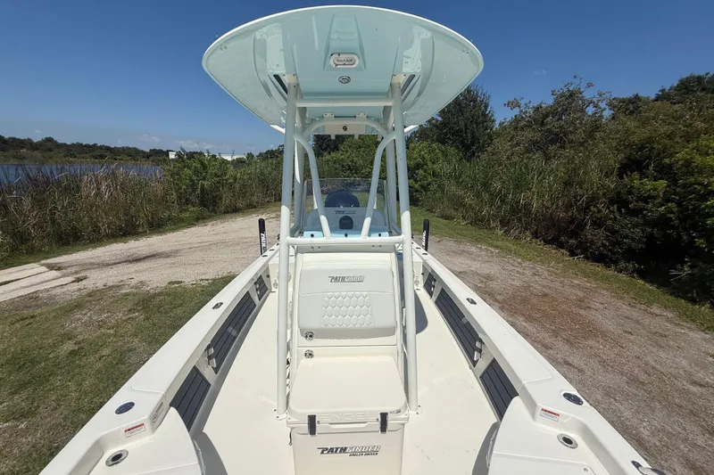 Slide: The Image of 2026 Pathfinder 2200 TRS boat on a grassy shoreline with clear blue sky. - 20