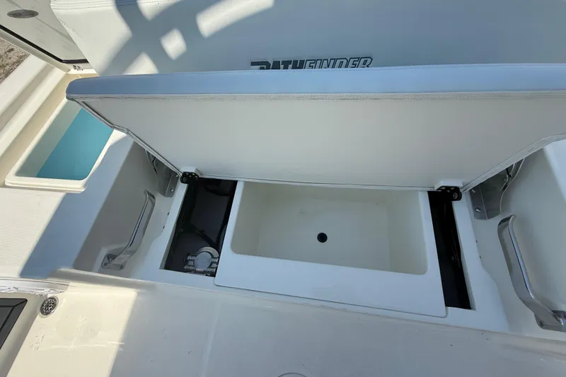 Slide: The Image of Pathfinder 2200 TRS 2026 boat storage compartment with open lid, showcasing interior space. - 27
