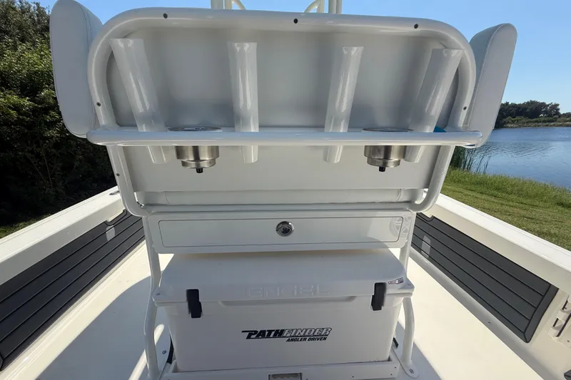 Slide: The Image of 2026 Pathfinder 2200 TRS boat interior with rod holders and storage, near a serene lake. - 29