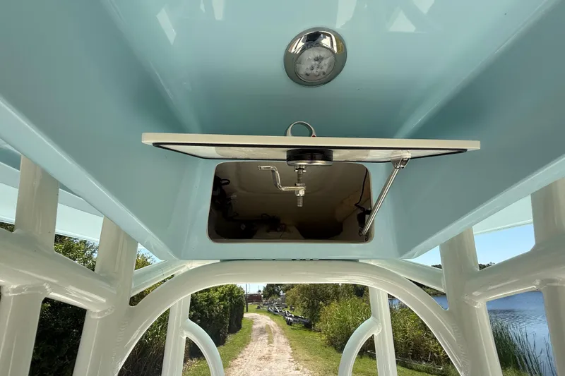 Slide: The Image of 2026 Pathfinder 2200 TRS boat interior, featuring a hatch and light fixture, with a scenic outdoor view. - 34