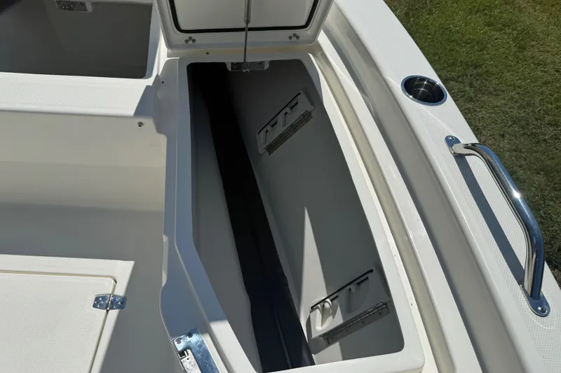 Slide: The Image of 2026 Pathfinder 2200 TRS boat storage compartment with open lid and cup holder. - 40