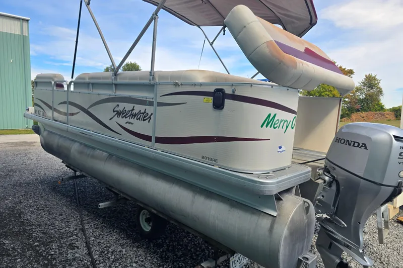 Slide: The Image of 2003 Sweetwater 2019RE pontoon boat with canopy and Honda motor, parked on gravel. - 3