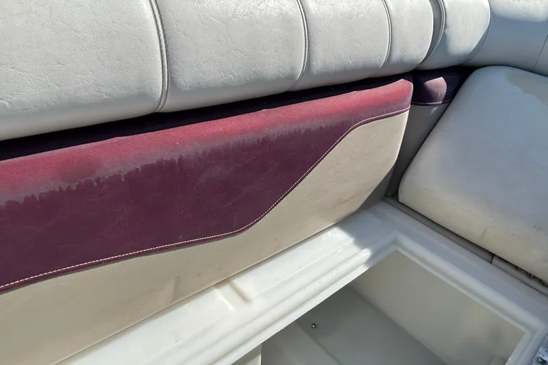 Slide: The Image of Sweetwater 2019RE 2003 boat seat with white and maroon upholstery under a sunny sky. - 65
