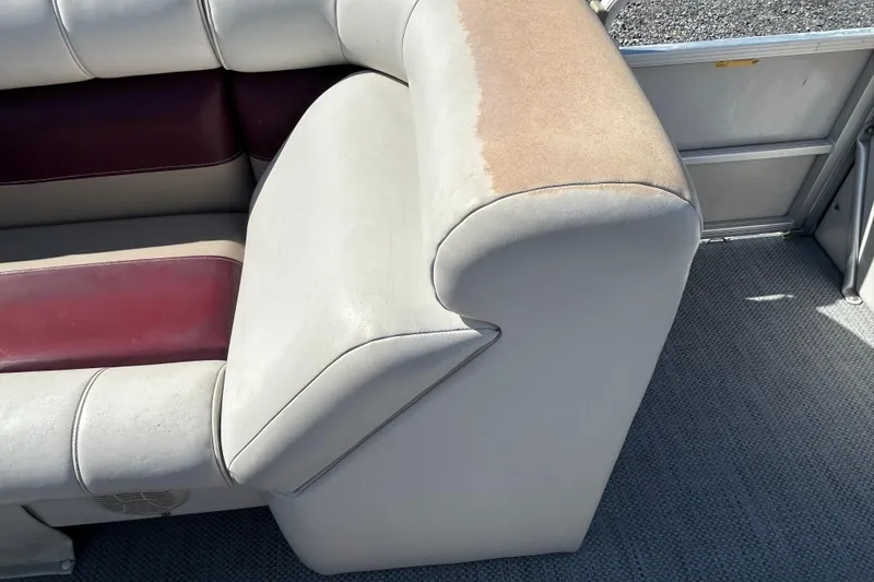 Slide: The Image of Worn seating on a 2003 Sweetwater 2019RE boat, showing faded upholstery and carpeted floor. - 74