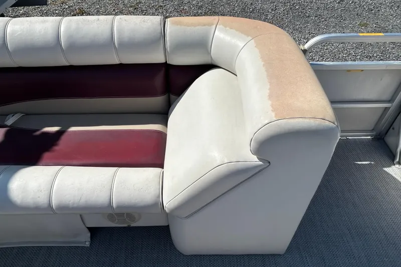 Slide: The Image of Pontoon boat seating with white and maroon upholstery, showing wear and sun damage. - 75