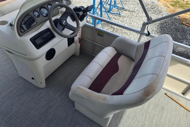 Slide: The Image of Sweetwater 2019RE pontoon boat, 2003 model, parked outdoors under a clear blue sky. - 8