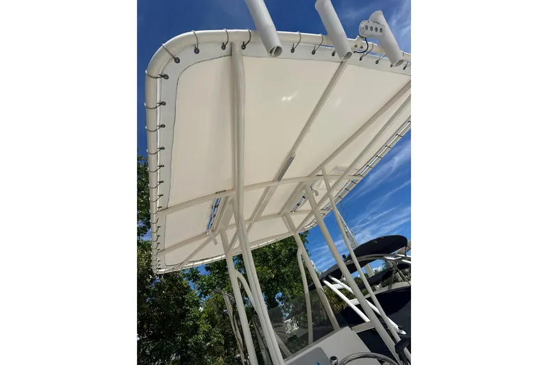 Slide: The Image of 2014 Pathfinder 2300 HPS boat canopy with rod holders under clear blue sky. - 8