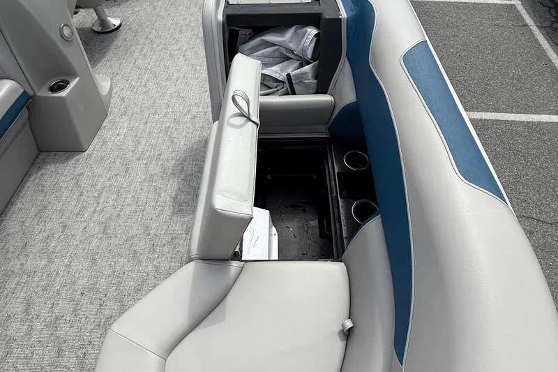 Slide: The Image of 2025 Berkshire 24RFX LE 2.75 boat interior with open storage compartment and cup holders. - 11
