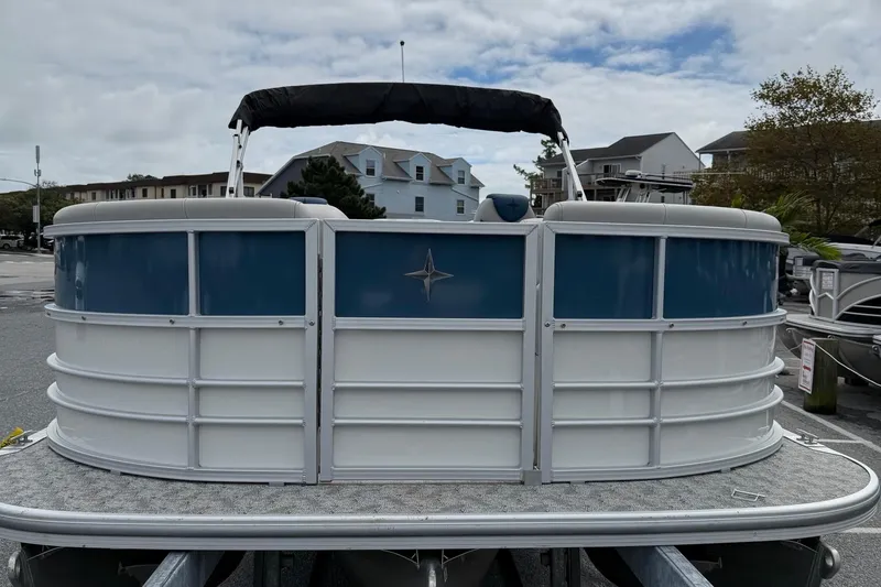 Slide: The Image of 2025 Berkshire 24RFX LE 2.75 pontoon boat, blue and white, docked outdoors. - 3