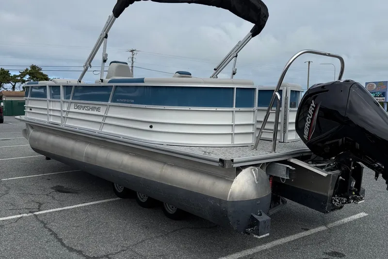 Slide: The Image of 2025 Berkshire 24RFX LE 2.75 pontoon boat with Mercury outboard motor in parking lot. - 6
