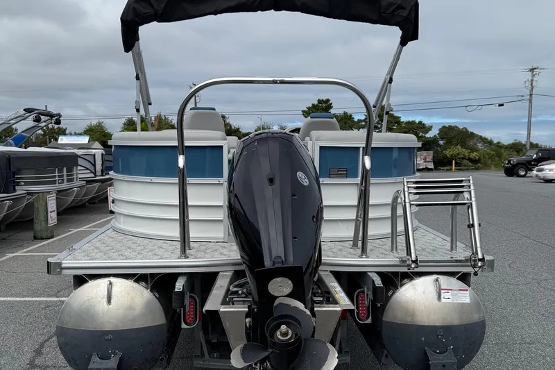 Slide: The Image of 2025 Berkshire 24RFX LE 2.75 pontoon boat with outboard motor in a parking lot. - 7