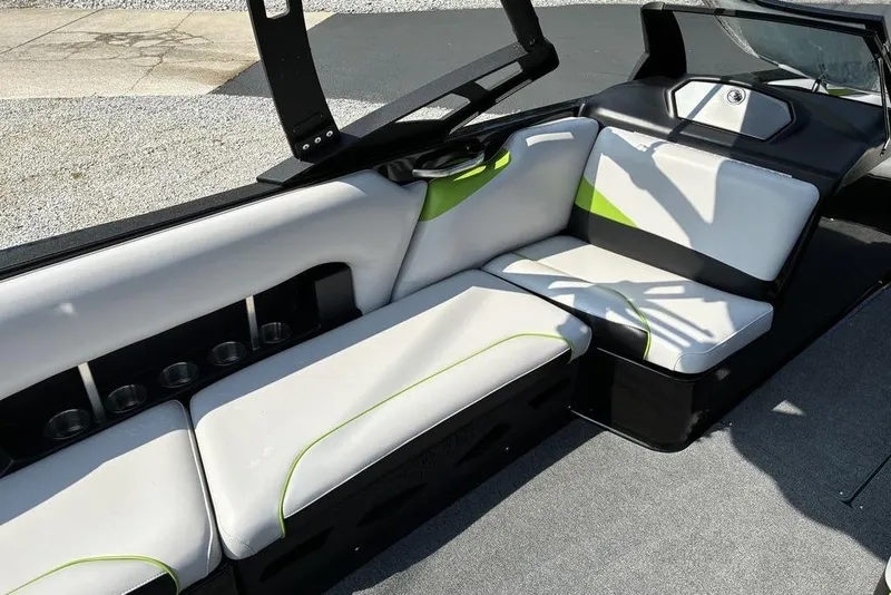 Slide: The Image of 2014 Axis A24 boat interior with white and green seating, cup holders, and sleek design. - 4