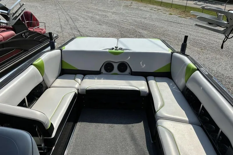 Slide: The Image of 2014 Axis A24 boat interior with white and green seating, outdoor setting. - 5