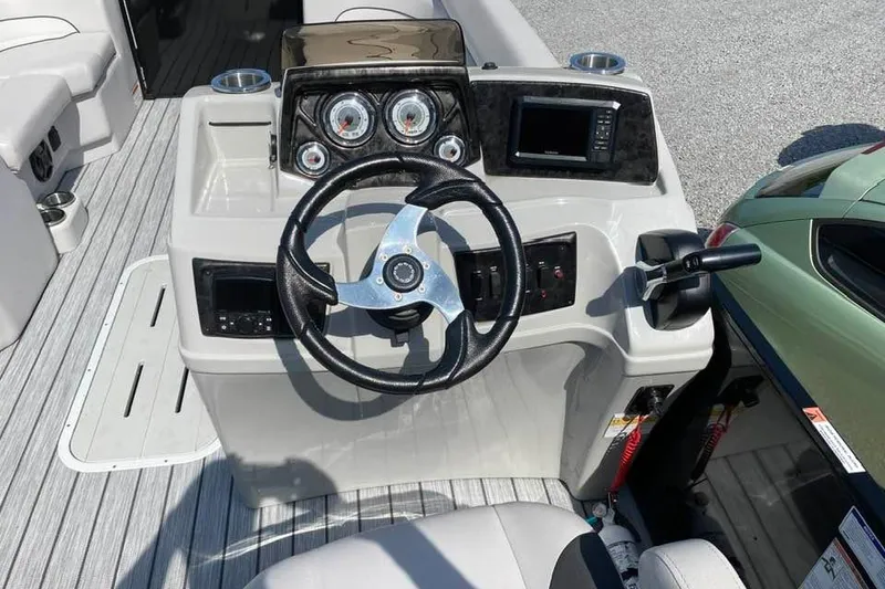 Slide: The Image of 2023 G3 Suncatcher Select Series 322RC boat dashboard with steering wheel and gauges. - 8