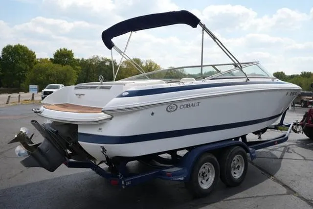 Slide: The Image of 2000 Cobalt 226 boat on trailer, white with blue accents, parked outdoors. - 2