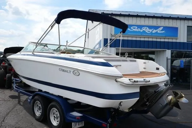 Slide: The Image of 2000 Cobalt 226 boat on trailer outside Sea Ray dealership, featuring sleek design and blue accents. - 4