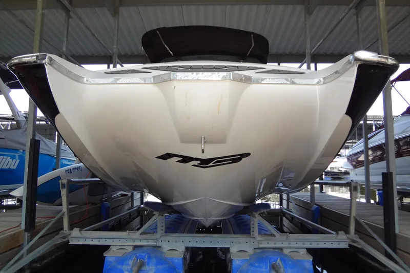 Slide: The Image of 2017 MB SPORTS F22 Tomcat boat on a lift in a covered dock. - 2