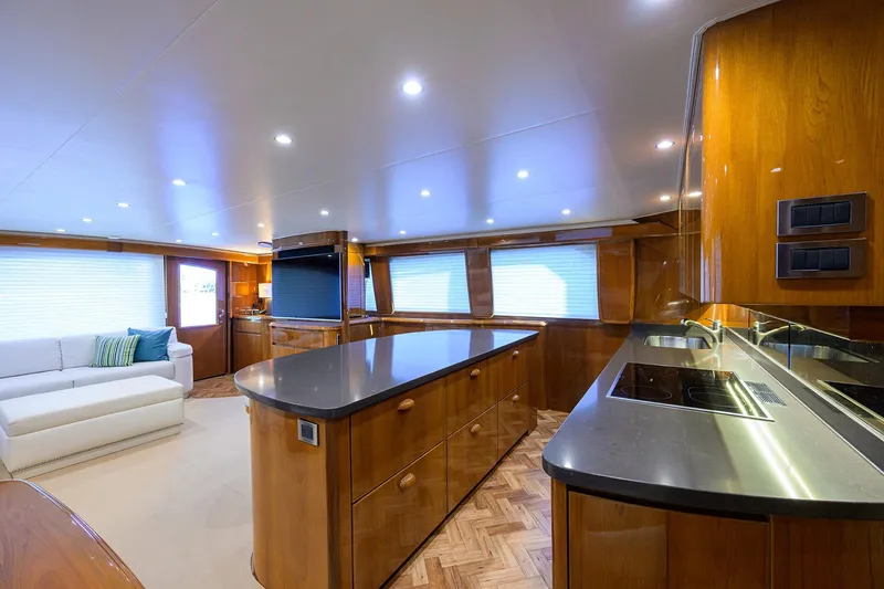 Slide: The Image of Luxurious interior of 2014 Viking 76 Enclosed Bridge Convertible yacht with modern kitchen and seating. - 14