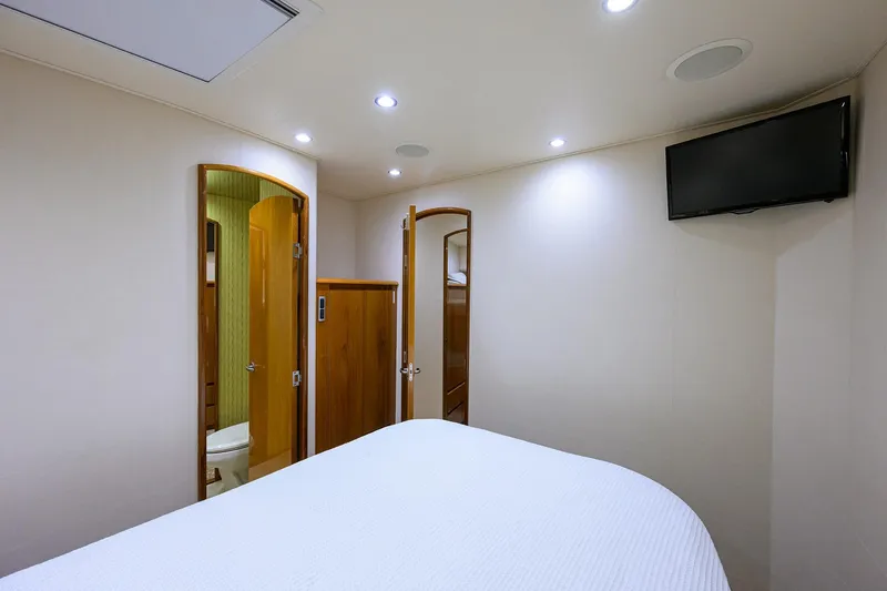 Slide: The Image of Interior of 2014 Viking 76 Enclosed Bridge Convertible yacht bedroom with TV and bathroom. - 33