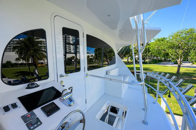 Slide: The Image of 2014 Viking 76 Enclosed Bridge Convertible yacht helm with modern controls and scenic view. - 48