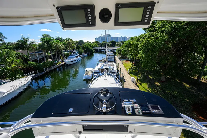 Slide: The Image of View from 2014 Viking 76 Enclosed Bridge Convertible yacht, overlooking marina and lush greenery. - 50
