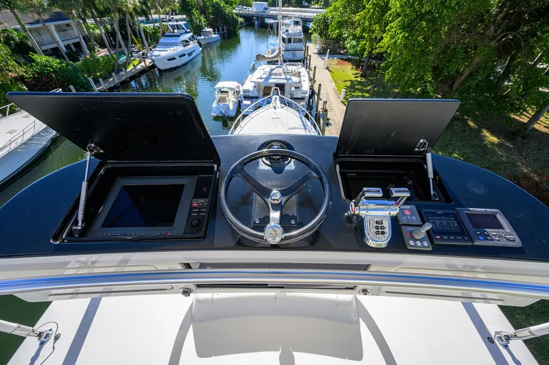 Slide: The Image of Control panel of 2014 Viking 76 Enclosed Bridge Convertible yacht, docked in a marina. - 52