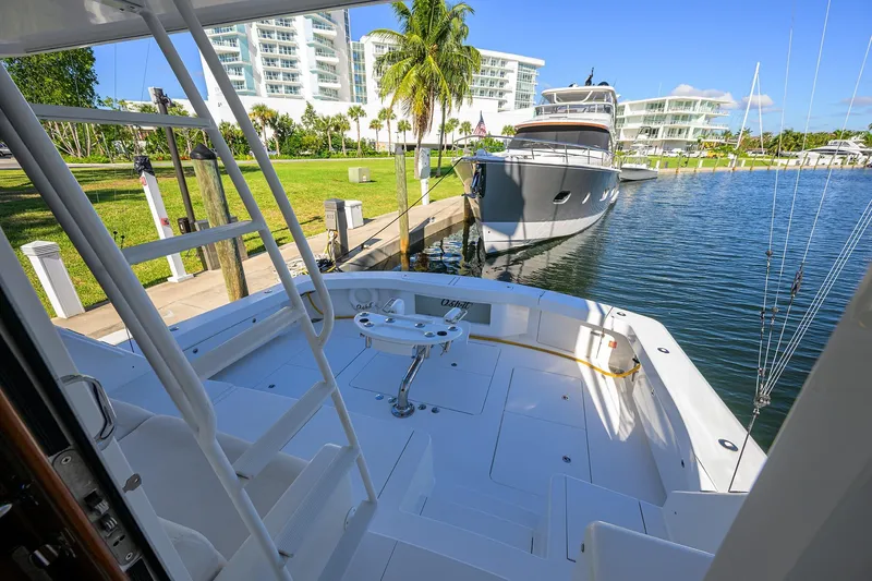 Slide: The Image of 2014 Viking 76 Enclosed Bridge Convertible yacht docked near luxury waterfront buildings. - 55
