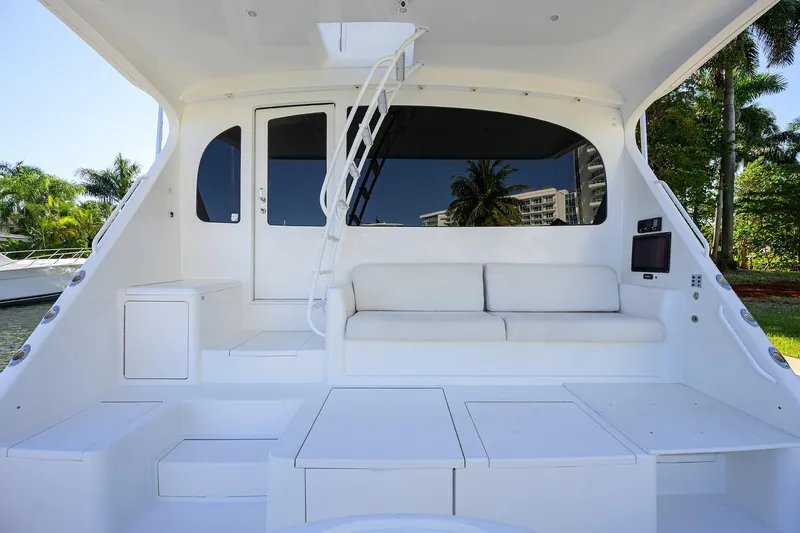Slide: The Image of 2014 Viking 76 Enclosed Bridge Convertible yacht interior with white seating and modern design. - 60
