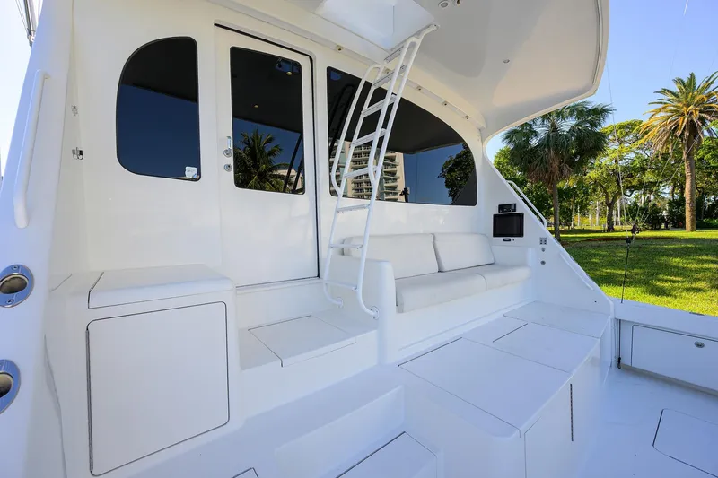 Slide: The Image of 2014 Viking 76 Enclosed Bridge Convertible yacht with white seating and outdoor view. - 61