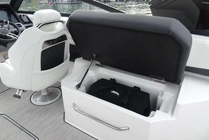 Slide: The Image of 2026 Cobalt R6 boat interior with open storage compartment and white captain's chair. - 10