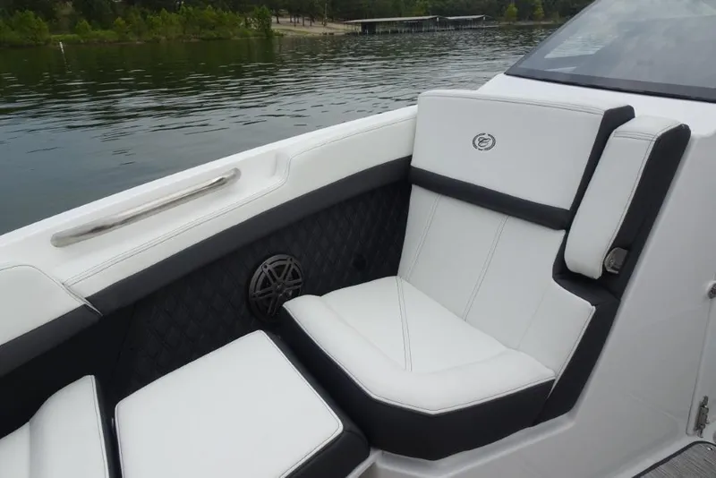 Slide: The Image of 2026 Cobalt R6 boat interior with white and black seating, on a calm lake. - 17
