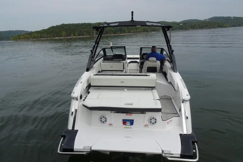 Slide: The Image of 2026 Cobalt R6 boat on a calm lake, rear view with lush green shoreline. - 6